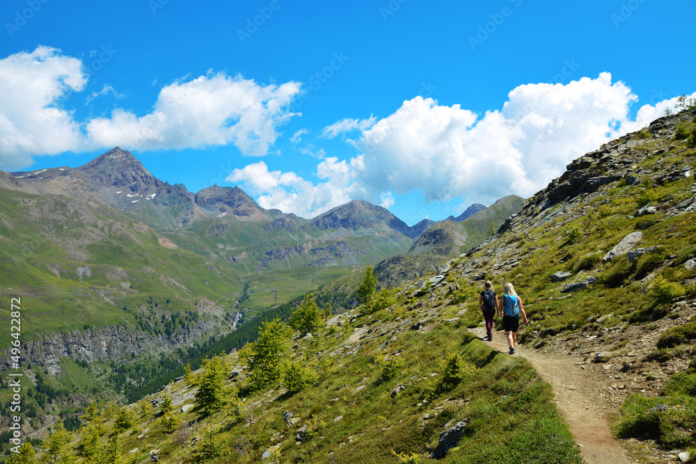 Hikers in the Gran Paradiso National Park. Aosta Valley, Italy. Beautiful mountain landscape in sunny day.