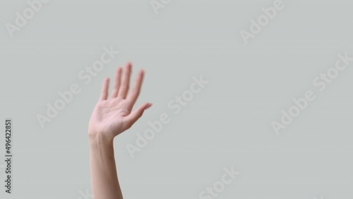 Hi gesture. Hello greeting. Friendly welcome. Meeting acquaintance. Female hand waving hey isolated on light neutral copy space advertising background. photo
