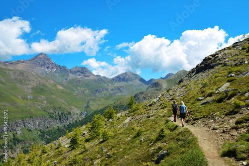 Hikers in the Gran Paradiso National Park. Aosta Valley, Italy. Beautiful mountain landscape in sunny day.