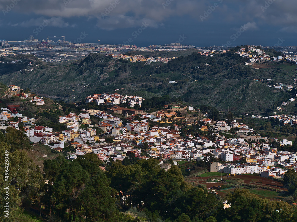 Beautiful aerial view of small town Teror in the northeast of island Gran Canaria, Canary Islands, Spain surrounded by green hills on cloudy day.