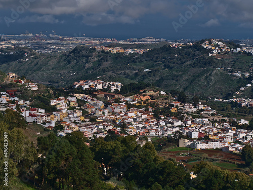 Beautiful aerial view of small town Teror in the northeast of island Gran Canaria, Canary Islands, Spain surrounded by green hills on cloudy day. © Timon