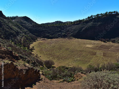 View of volcanic crater Caldera de Los Marteles in the central mountains of island Gran Canaria, Spain on sunny day with green meadows and forests. photo