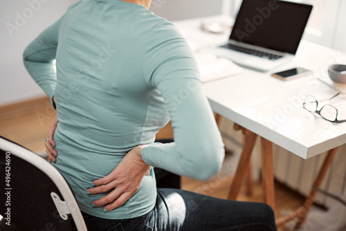 Woman with hip, back, spine spasm, cramp and pain, working from home troubles and issues. © astrosystem