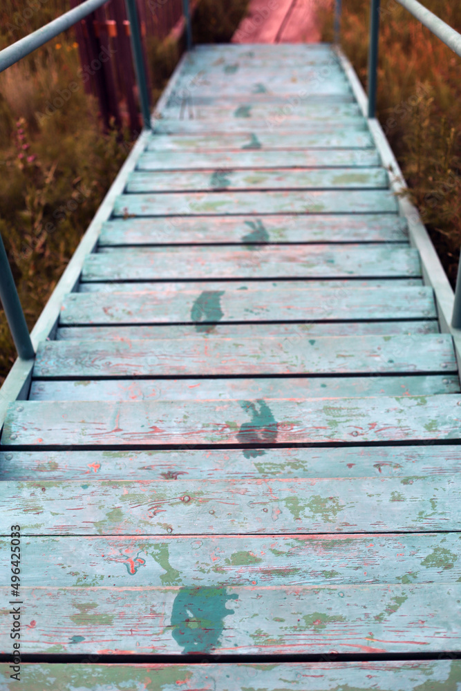 Obraz premium an old blue staircase that leads down to the shore.