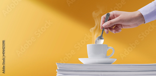 Woman stirring coffee and taking a break photo