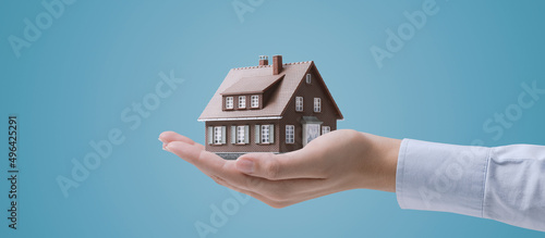 Hand holding a model house
