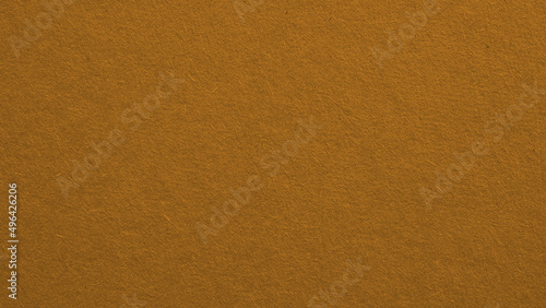 The surface of bright brown cardboard. Paperboard wallpaper. Textured pasteboard background. Paper texture with cellulose fibers. Macro