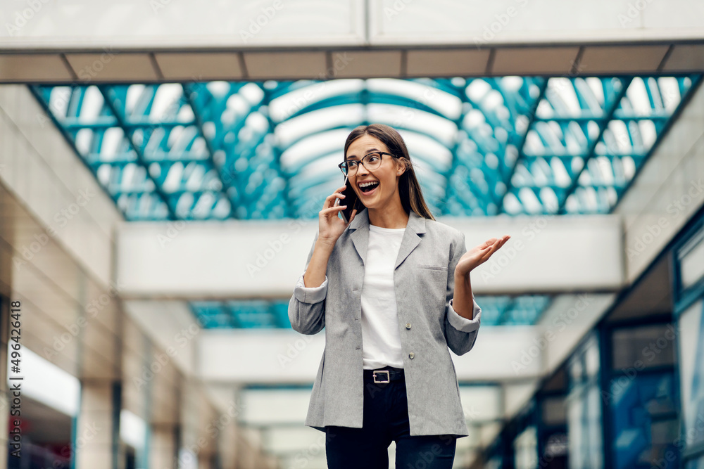Fototapeta premium A businesswoman at the business center receiving a good news on the phone.