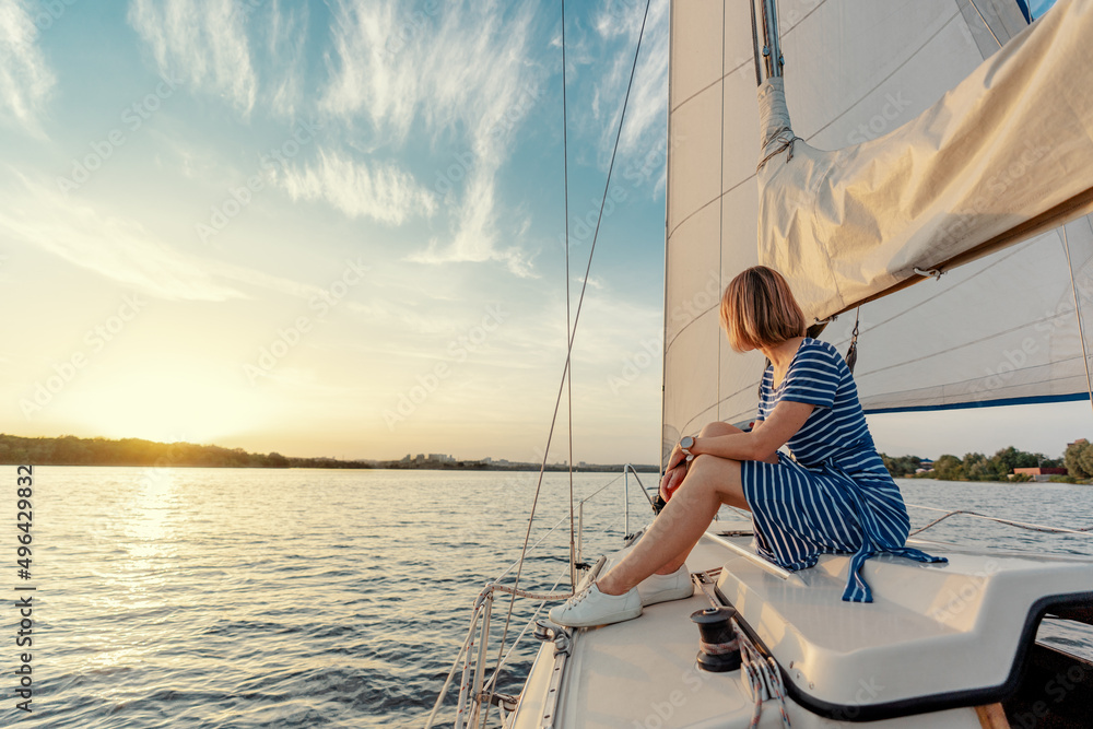 Luxury travel on the yacht. Young happy woman on boat deck sailing the river. Luxury travel on the yacht. Young happy woman on boat deck sailing the river.