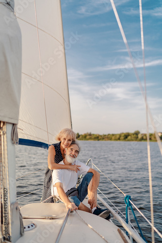 Romantic vacation and luxury travel. Senior loving couple sitting on the yacht deck. Sailing the sea.