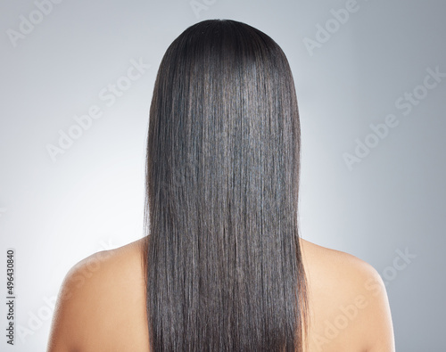 Dead straight hair is easy to manage. Shot of an unrecognisable woman standing alone in the studio.