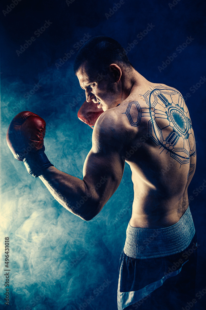  Side view of sportsman muscular boxer who fighting on black smoke background. Boxing sport concept
