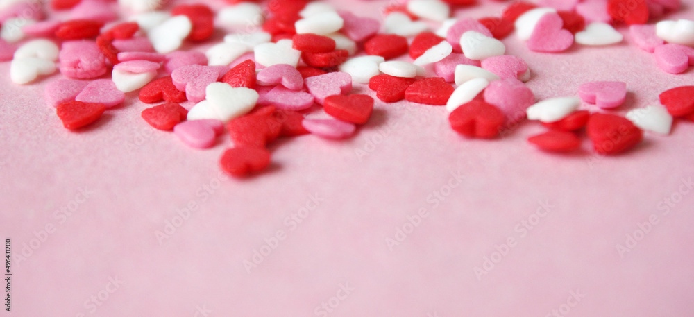 Multicolored background with candy hearts. Pink, white, red hearts. Love. Simovl loves. Valentine's Day. Lots of little hearts. Banner. Copy space for text.