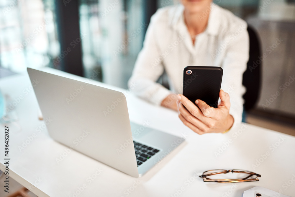 Using her connections to get ahead. Closeup shot of an unrecognisable businesswoman using a cellphone and laptop in an office. Using her connections to get ahead. Closeup shot of an unrecognisable businesswoman using a cellphone and laptop in an office.