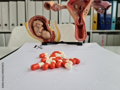 Medical pills baby fetus and uterus on table closeup photo
