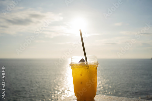 Orange juice on table seaside during sunset sky. 