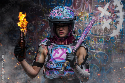 Tattooed woman activist with molotov holding baseball bat photo