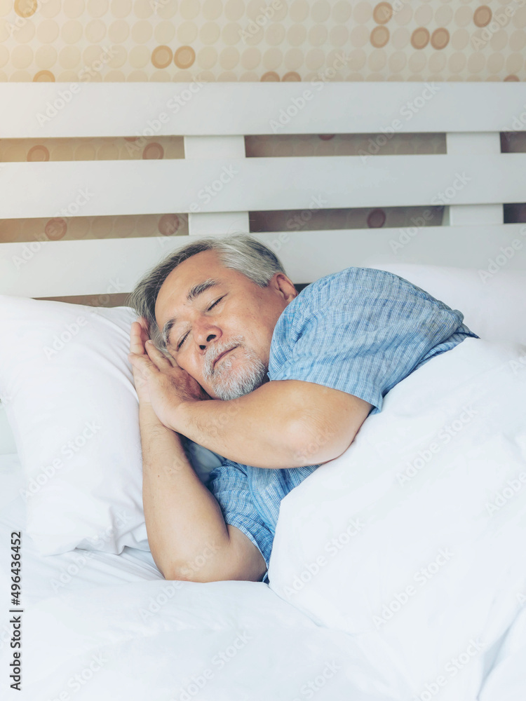 Senior male , old man sleeping on the pillow on white bed room in the morning - lifestyle senior male good health concept Senior male , old man sleeping on the pillow on white bed room in the morning - lifestyle senior male good health concept