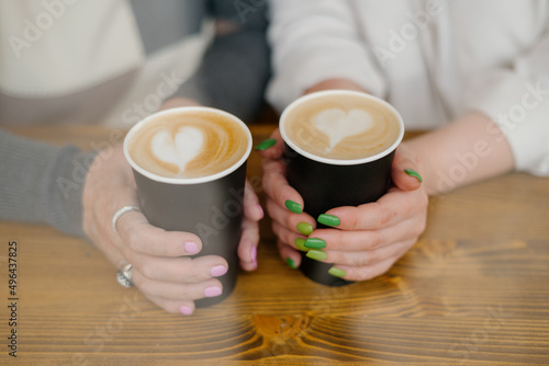 cups of coffee in female hands with heart symbol