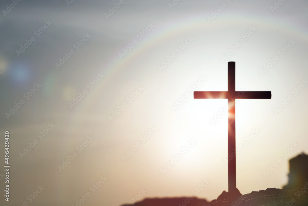 Naklejka premium 무지개 하늘과 구름 그리고 태양빛에 빛나는 예수그리스도의 죽음과 부활을 상징하는 거룩한 십자가 배경 
