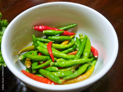 Top view of green and red pepper or chili in white bowl as a background for sale in the market at Thailand, abstract background, ready for cooking or eat
