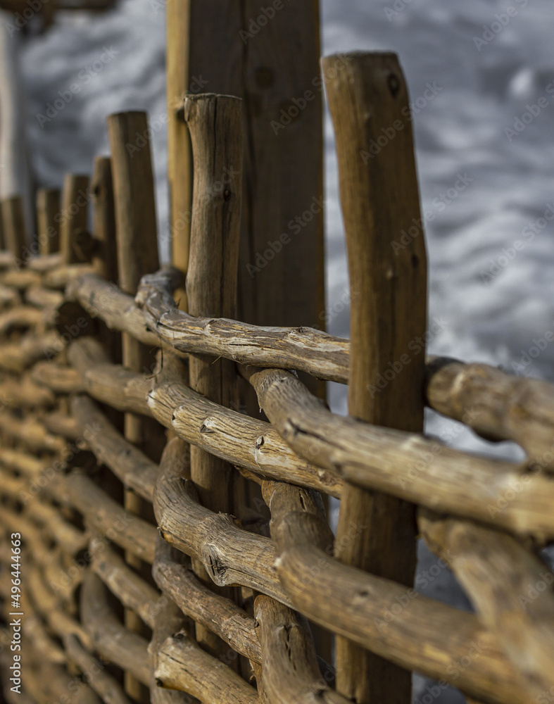 Wicker fence made of old wood. Wicker wooden fence. A fence made of intertwined branches. Wicker fence made of old wood. Wicker wooden fence. A fence made of intertwined branches.