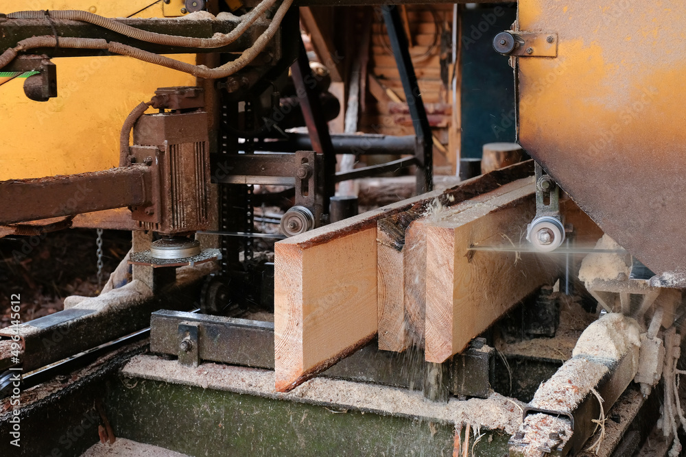 The process of sawing wood at a sawmill.