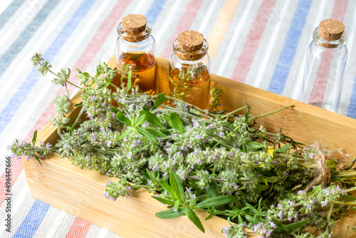 Blooming thyme  glass bottles with aromatic oil in a wooden box on the background of a cotton tablecloth. The concept of body care  alternative medicine