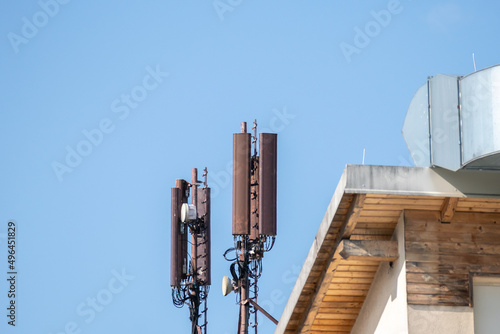 Mobile phone and internet cell tower over against sky. 5G wireless radiation antennas.