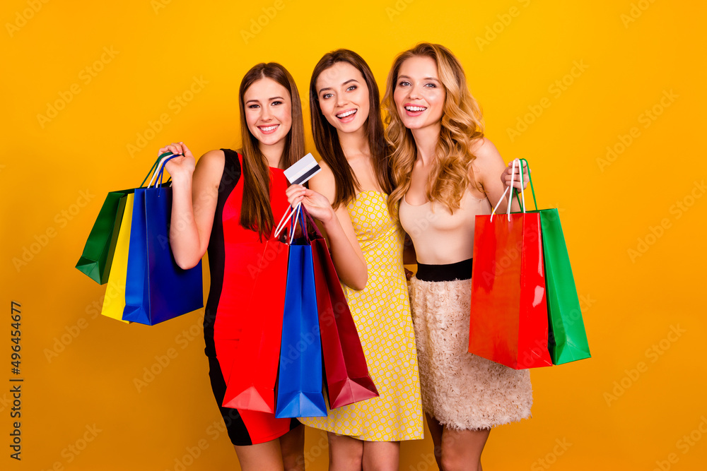 Photo of pretty glamorous ladies sisters in store use plastic contactless credit card bachelorette presents isolated yellow color background