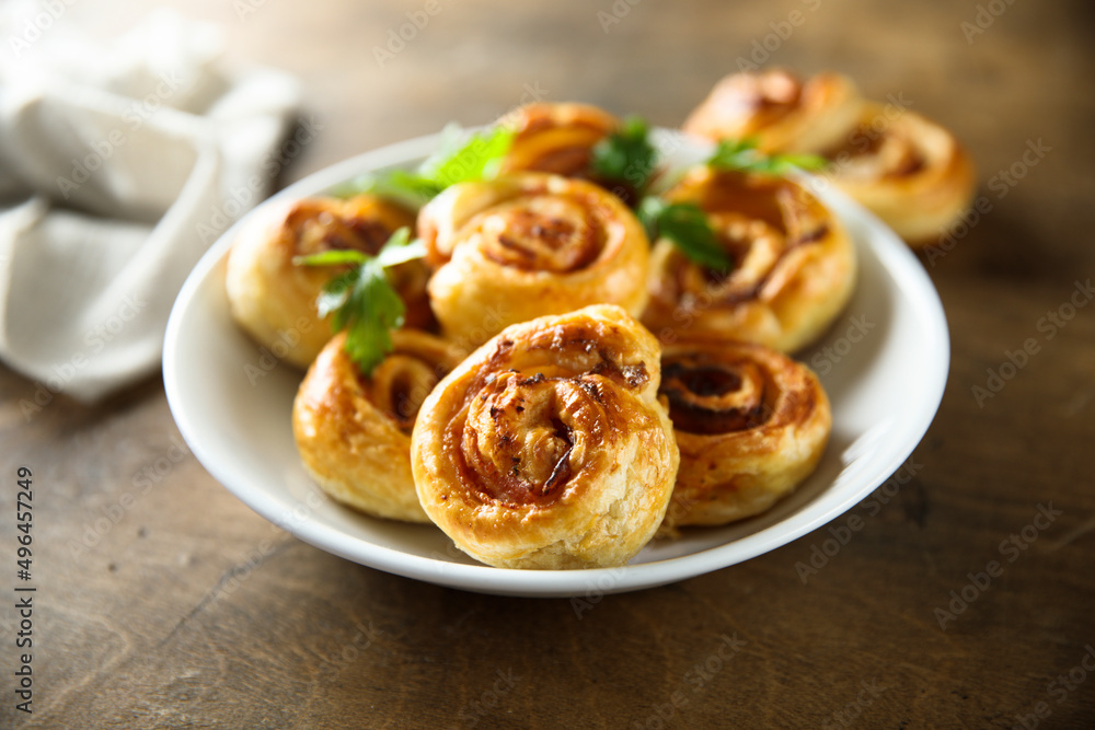 Homemade puff pastry swirls with bacon and tomato