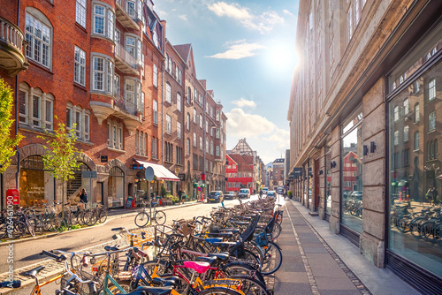 Many parked bikes on a narrow old Minter Street Møntergade in the Old Town of Copenhagen, Denmark photo