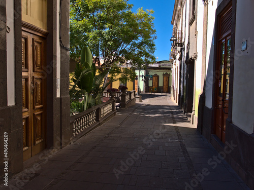 View of empty narrow alley in the historic center of Arucas on island Gran Canaria, Canary Islands, Spain on sunny day with old buildings and park. photo