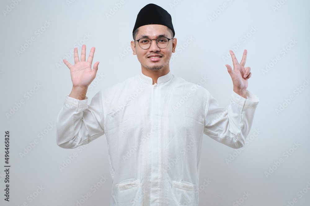 Asian muslim man wearing casual clothes showing and pointing up with fingers number eight while smiling confident and happy Asian muslim man wearing casual clothes showing and pointing up with fingers number eight while smiling confident and happy