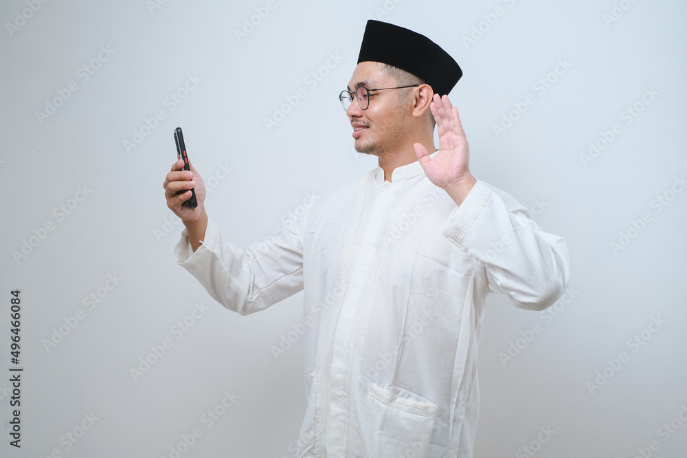 Asian muslim man doing video call with his smartphone Asian muslim man doing video call with his smartphone