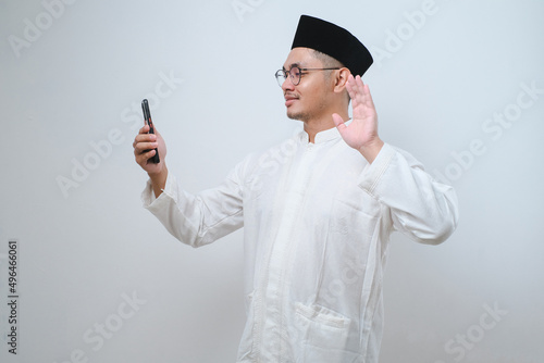 Asian muslim man doing video call with his smartphone