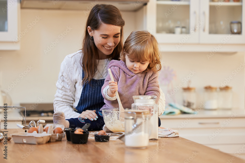 Making memories with my little girl. Shot of a young woman helping her daughter stir a bowl of batter. Making memories with my little girl. Shot of a young woman helping her daughter stir a bowl of batter.