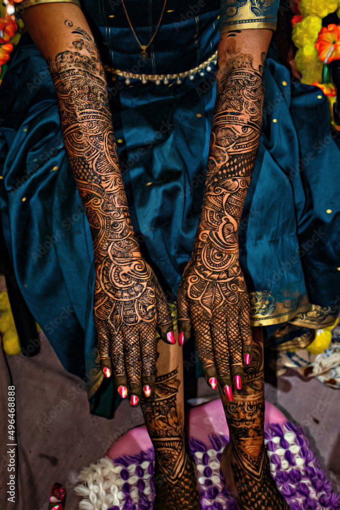 Fototapeta premium Stock photo of beautiful Indian bridal showing her henna hands, applied on the occasion of wedding at Kolhapur, Maharashtra, India. Henna symbolizes positive spirit and good luck for bride and groom.