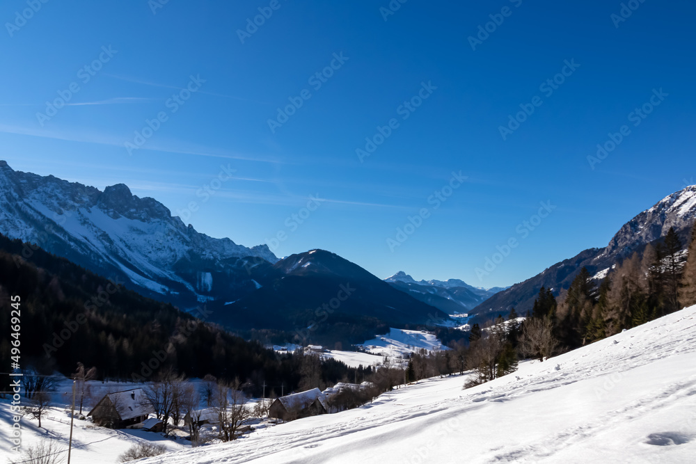 Panoramic view on snow capped mountain peaks of Karawanks in Carinthia, Austria. Julian Alps. Winter wonderland in the Austrian Alps, Europe. Ski touring. Hochobir. Mountain village Zell Sele
