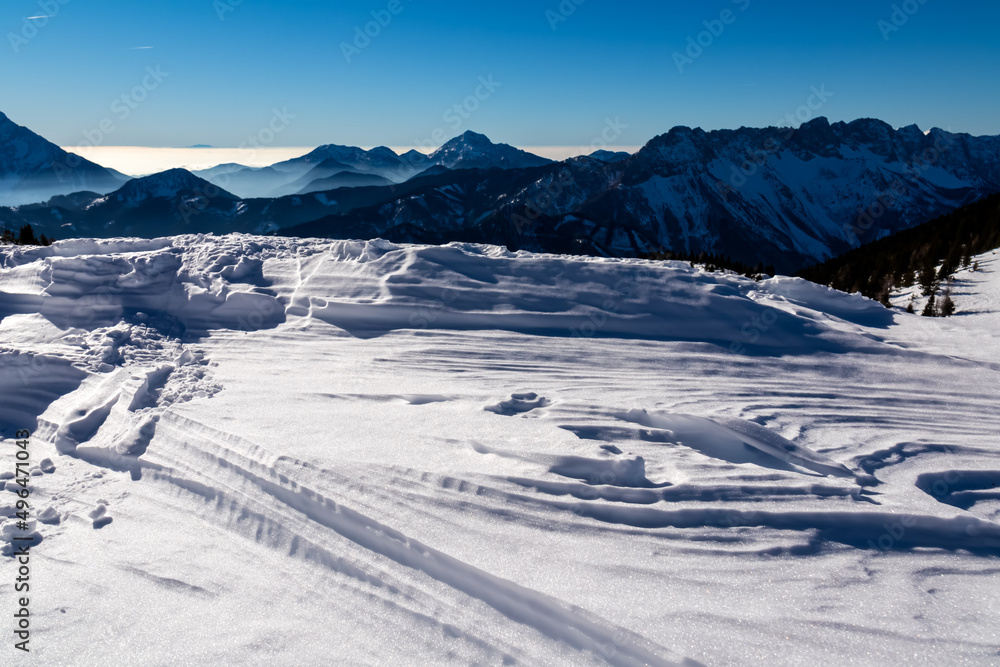 Panoramic view on snow capped mountain peaks of Karawanks in Carinthia, Austria. Julian Alps. Winter wonderland in the Austrian Alps, Europe. Ski tour, snow shoe hiking. Hochobir. Blue misty hills. Panoramic view on snow capped mountain peaks of Karawanks in Carinthia, Austria. Julian Alps. Winter wonderland in the Austrian Alps, Europe. Ski tour, snow shoe hiking. Hochobir. Blue misty hills.