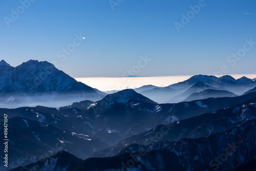Panoramic view on snow capped mountain peaks of Karawanks in Carinthia  Austria. Julian Alps. Winter wonderland in the Austrian Alps  Europe. Ski tour  snow shoe hiking. Hochobir. Blue misty hills.