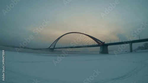 in the early morning a blizzard with snow sweeps and the sun slowly illuminates the transport bridge in siberia photo