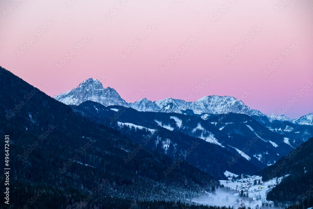 Sunrise over snow capped mountain peaks of Karawanks in Carinthia, Austria. Julian Alps. Scenic view on winter wonderland at dawn in the Austrian Alps, Europe. Ski tour, snow shoe hiking. Hochobir