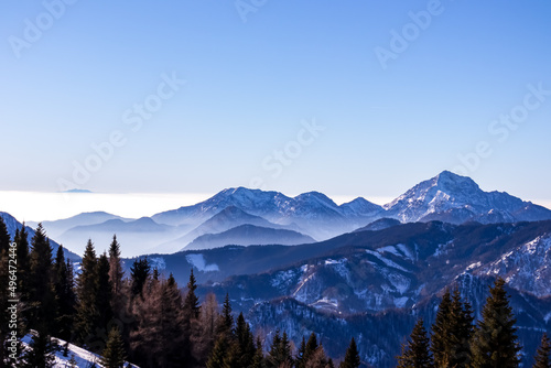 Panoramic view on snow capped mountain peaks of Karawanks in Carinthia, Austria. Julian Alps. Winter wonderland in the Austrian Alps, Europe. Ski tour, snow shoe hiking. Hochobir. Blue misty hills.