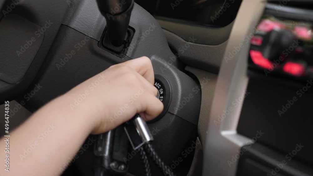 Close-up of a little boy turning the ignition key while driving a car. The child is playing in Dad's car. Close-up of a little boy turning the ignition key while driving a car. The child is playing in Dad's car.