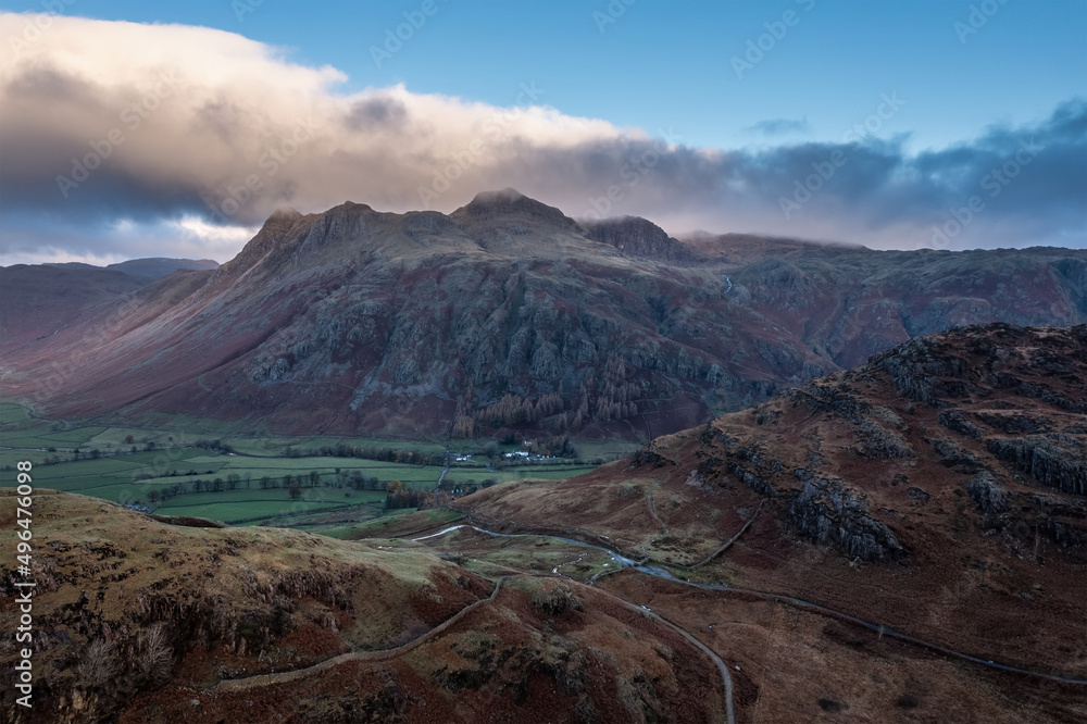 Beautiful aerial drone landscape image of sunrise from Blea Tarn in Lake District during stunning Autumn showing