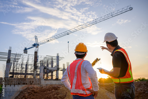 A team of construction engineers talks to managers and construction workers at the construction site. Quality inspection, work plan, home and industrial building design project photo