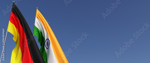 Flags of Germany and India on flagpoles on side. Flags on a blue background. Place for text. German, Berlin. New Delhi. 3D illustration.