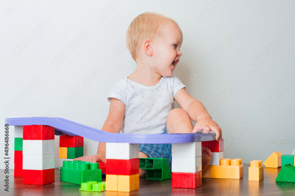 Happy toddler boy playing educational constructor himself close-up and copy space...