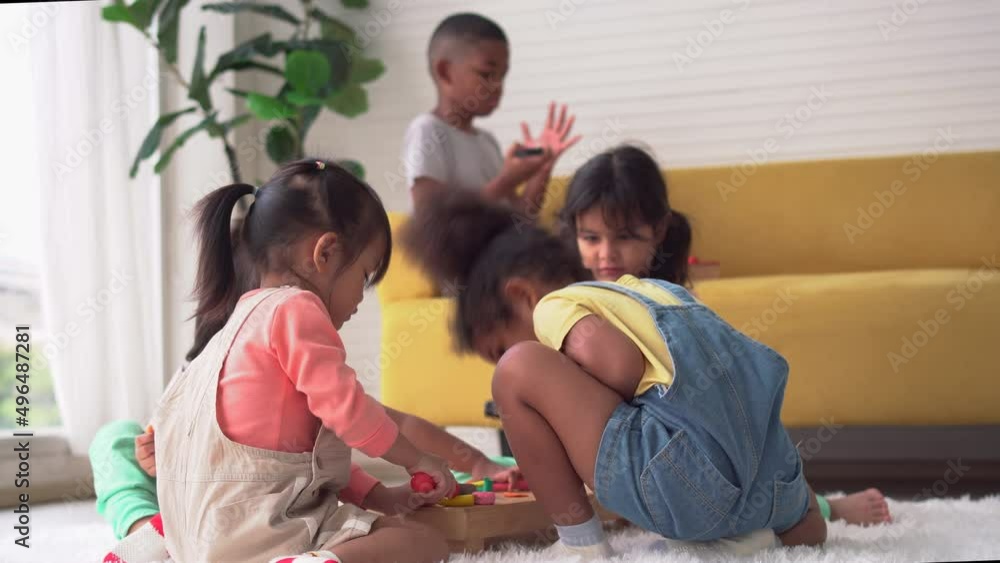 Children playing toy and game in living room, Group of friends, Little girls and boy mould from plasticine on the floor Children playing toy and game in living room, Group of friends, Little girls and boy mould from plasticine on the floor